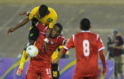 Jamaica&#039;s Demar Phillips (top) fouls Panama&#039;s Alex Rodriguez at the National Stadium March 22, 2013, in Kingston