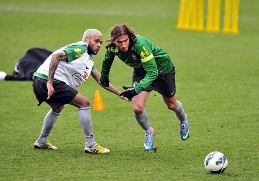 Brazil&#039;s Filipe Luis (R) and Daniel Alves are pictured during a training session at Stamford Bridge on March 24, 2013