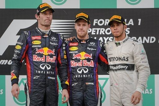 Sebastian Vettel (C) at the podium with second-placed Mark Webber (L) and third-placed Lewis Hamilton on March 24, 2013