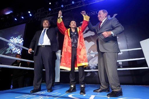 Zou Shiming (C) is pictured after signing with US promoter Bob Arum (R) during a ceremony in Beijing on January 23, 2013