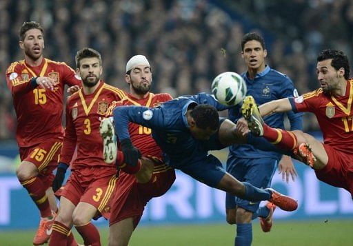 France defender Patrice Evra heads the ball away from the stretching Alvaro Arbeloa on March 26, 2013