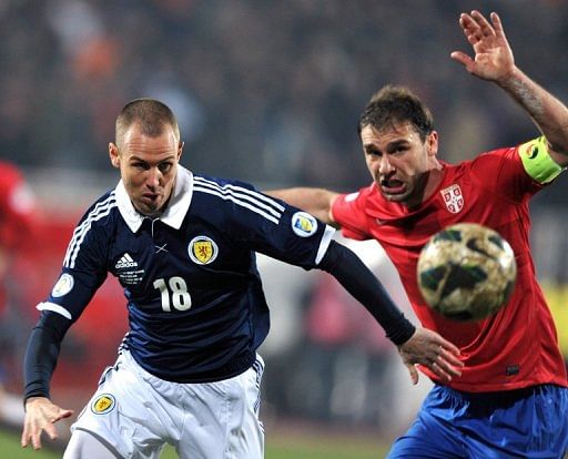 Kenny Miller (L) battles with Branislav Ivanovic during their World Cup qualifier on March 26, 2013