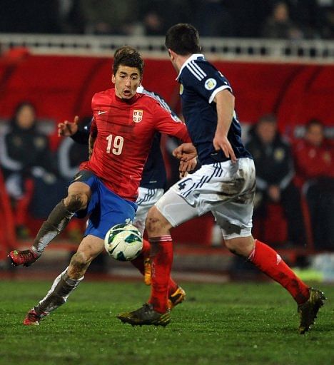 Serbia&#039;s Filip Djuricic (L) runs at the Scotland defence on March 26, 2013