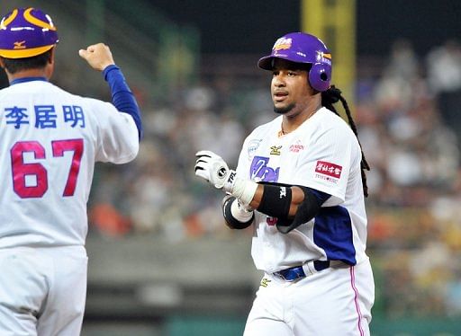 Manny Ramirez, former Boston Red Sox slugger, reacts to a team coach in his debut game in Kaohsiung on March 27, 2013
