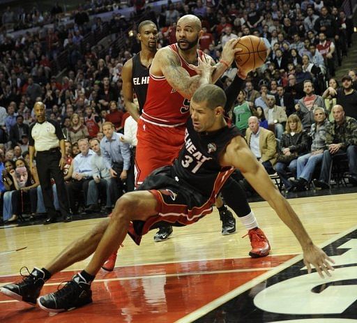 Shane Battier (R) of the Miami Heat falls to the floor under pressure from Carlos Boozer on March 27, 2013