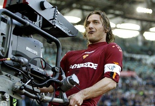 Francesco Totti celebrates with a TV camera after scoring at Rome's Olympic stadium on April 21, 2004