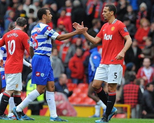 Anton Ferdinand shakes hands with brother Rio Ferdinand (R) at Old Trafford in Manchester, on April 8, 2012