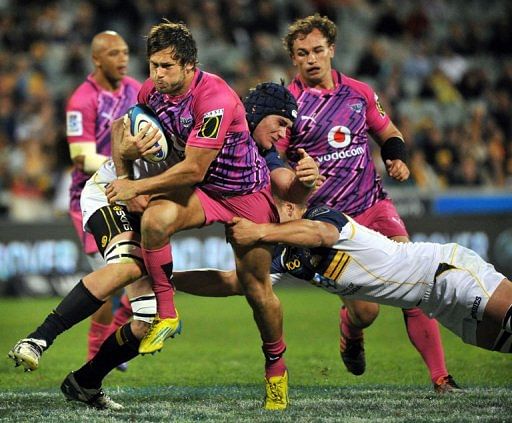 Jan Serfontein (C) of the Bulls is tackled by Brumbies players, in Canberra, on March 30, 2013