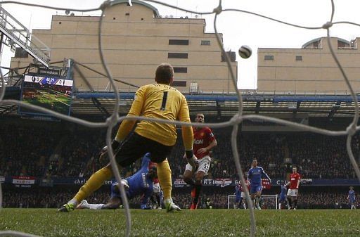 Chelsea&#039;s Demba Ba (L) scores past Manchester United&#039;s goalkeeper David De Gea in London on April 1, 2013