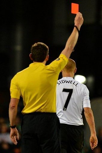 Fulham midfielder Steve Sidwell (R) receives a red card after tackling QPR defender Armand Traore on April 1, 2013