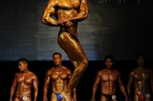 A bodybuilder flexes his muscles on stage during the final SEA Games selection contest in Yangon on February 12, 2013
