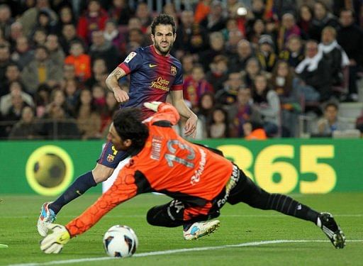 Barcelona&#039;s Cesc Fabregas (up) scores a goal against Mallorca&#039;s goalkeeper Dudu Aouate in Barcelona, April 6, 2013