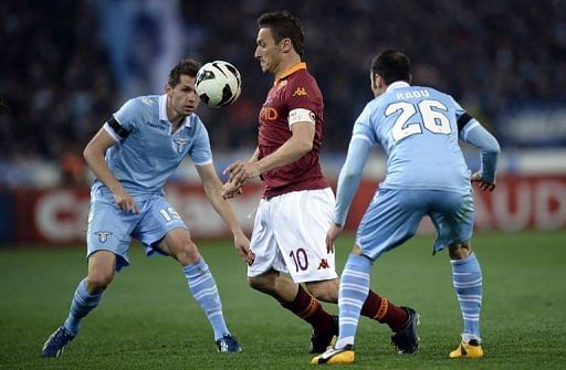 AS Roma&#039;s Francesco Totti (C) vies with Lazio&#039;s Senad Lilic (L) and Stefan Radu on April 8, 2013 at the Olympic stadium