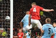 United's Phil Jones (C) wins a header that deflects in off City's Vincent Kompany (L) at Old Trafford on April 8, 2013