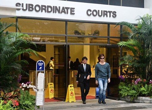 Singaporean businessman Eric Ding, 31, (R) leaves the Subordinate courts in Singapore on April 9, 2013
