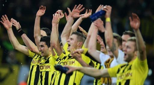 Dortmund players celebrate after they defeat Malaga in the Champions League quarter-final second-leg on April 9, 2013