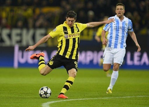 Dortmund striker Robert Lewandowski (L) shoots during their Champions League match against Dortmund on April 9, 2013