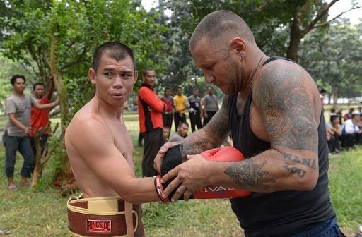 World featherweight champion Chris John is helped by coach Craig Christian during a training session on April 3, 2013