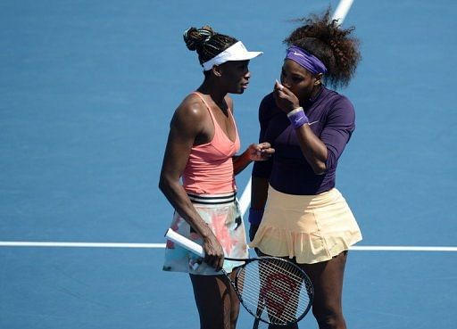 Serena (R) and Venus Williams (L) of the US speak after a point during a women&#039;s doubles in Melbourne, January 20, 2013