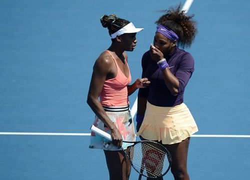 Serena (R) and Venus Williams (L) of the US speak after a point during a women's doubles in Melbourne, January 20, 2013