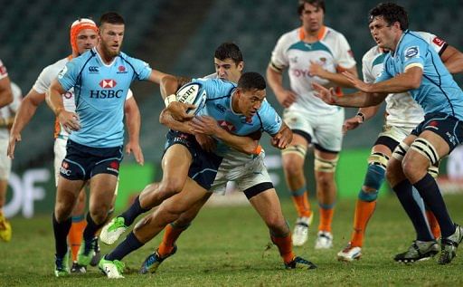 Israel Folau (C) from the Waratahs of Australia tries to dodge a tackle by the Cheetahs players, on March 15, 2013