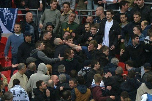 Millwall fans fight in the crowd during the FA Cup semi-finals at Wembley Stadium in north London, April 13, 2013