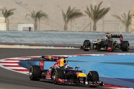 Lotus driver Romain Grosjean (R) and Red Bull&#039;s Sebastian Vettel, drive in Manama, on April 22, 2012