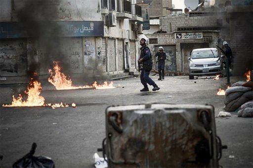 Bahraini police flee petrol bombs during clashes in the village of Sanabis, west of Manama, on April 13, 2013