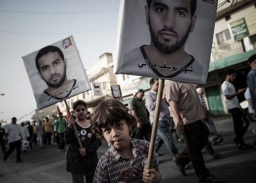 A Bahraini boy holds a poster of a victim of protest violence during an anti-regime rally in Jidhafs on April 15, 2013