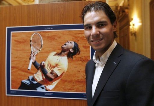 Rafael Nadal poses in front of a picture of the 2012 final of the Monte-Carlo tournament, on April 13, 2013