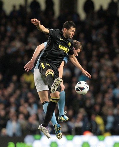 Manchester City's Edin Dzeko (R) goes for a high ball against Wigan's Antolin Alcaraz on April 17, 2013 Manchester City's Edin Dzeko (R) goes for a high ball against Wigan's Antolin Alcaraz on April 17, 2013