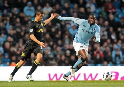 Manchester City's Yaya Toure (R) races for the ball against Wigan's Franco Di Santo in Manchester on April 17, 2013. Manchester City's Yaya Toure (R) races for the ball against Wigan's Franco Di Santo in Manchester on April 17, 2013.