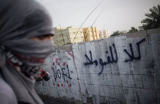 A Bahraini protester writes graffiti against the Bahrain Formula One Grand Prix in Jid Ali village, April 17, 2013.