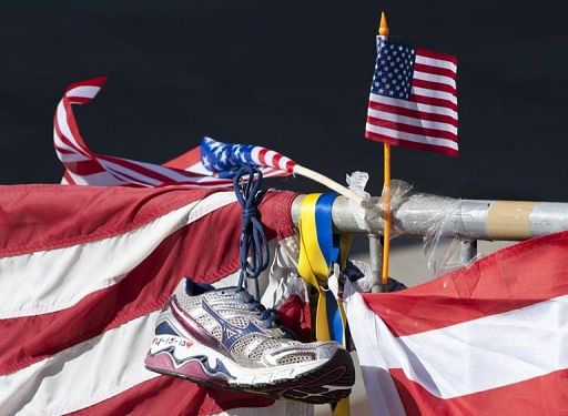 A running shoe and US flag are part of a memorial on the Boston Marathon route on April 18, 2013 in Boston