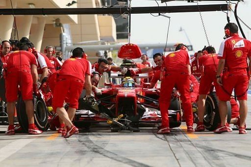 Ferrari mechanics change tyres on Felipe Massa&#039;s car at the Bahrain International Circuit in Manama, on April 19, 2012