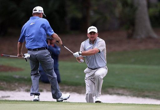 Jerry Kelly helps Graeme McDowell out of a bunker during the final round of the RBC Heritage on April 21, 2013