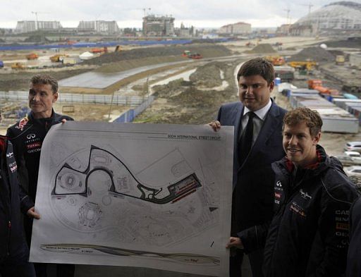 Sebastian Vettel (right), poses with a map of Russian Grand Prix circuit in Sochi on April 22, 2013