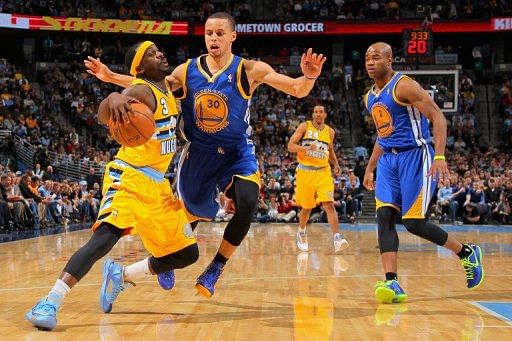 Ty Lawson (L) drives with the ball against Stephen Curry on April 23, 2013