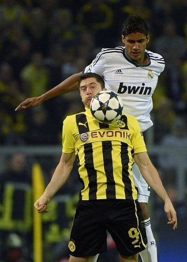 Real Madrid&#039;s Raphael Varane and Dortmund&#039;s Robert Lewandowski vie for the ball on April 24, 2013