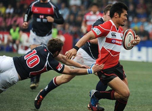 Japan&#039;s Yuta Imamura (right) is tackled by Niall Rowark during their Asian Five Nations match in Hong Kong, April 27, 2013