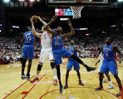 Omer Asik of the Houston Rockets reaches for a rebound against Kevin Durant of the Oklahoma City Thunder, April 27, 2013