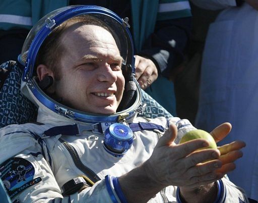 Cosmonaut Oleg Kotov holds an apple after the landing of a Russian Soyuz space capsule near Dzhezkazgan on June 2, 2010