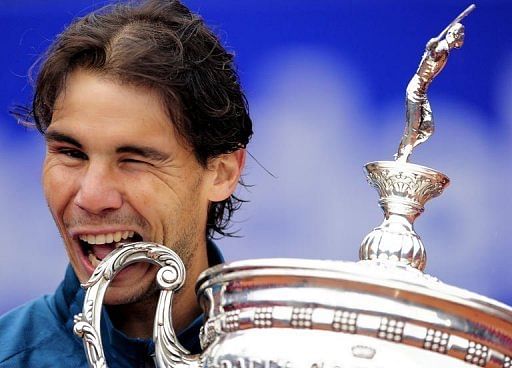 Spanish player Rafael Nadal bites his trophy as he celebrates his victory in Barcelona on April 28, 2013