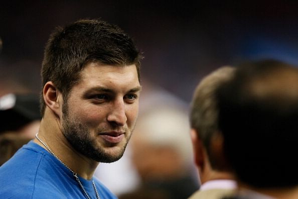 Tim Tebow fan Bob Brown, wearing a University of Florida jersey, cheers as  New York Jets quarterback Tim Tebow leaves the field after warming up prior  to an NFL football game against