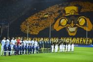 Dortmund's fans wave with yellow colours as the team pose for a family picture before the UEFA Champions League quarter-final second-leg football match Borussia Dortmund vs Malaga CF in Dortmund, western Germany on April 9, 2013.