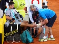 Novak Djokovic of Serbia receives treatment to his right ankle in his match against Grigor Dimitrov of Bulgaria during day four of the Mutua Madrid Open tennis tournament at the Caja Magica on May 7, 2013 in Madrid, Spain. (Photo by Julian Finney/Getty Images)