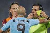 referee Paparesta (R) gives the yellow card to Lazio's Paolo Di Canio, flanked by AS Roma's Francesco Totti during an Italian Serie A match AS Roma-Lazio in Rome 23 October 2005. The match ended drawn 1-1. (Photo credit should read CARLO BARONCINI/AFP/Getty Images)