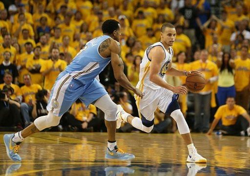 Golden State Warriors&#039; Stephen Curry (R) drives past the Denver Nuggets&#039; Andre Iguodala on May 2, 2013.