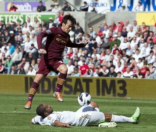 Swansea City&#039;s Ashley Williams (bottom) blocks a shot from Manchester City&#039;s David Silva in Swansea, on May 4, 2013
