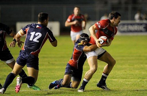 Alastair Maclay of Hong Kong (R) is tackled by Philippine rugby player Darran Seeto in Manila on May 4, 2013